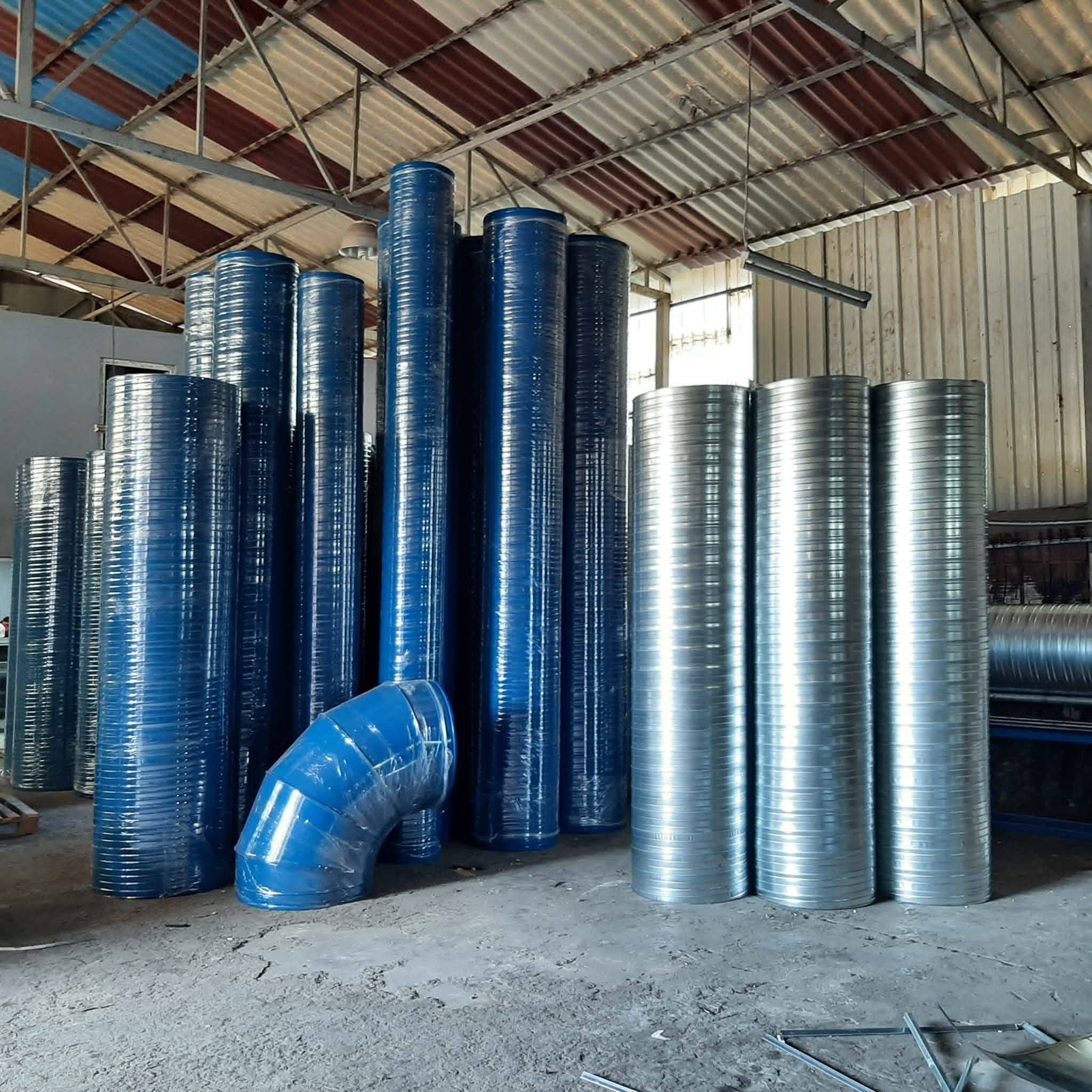 Atölyede farklı çaplarda imal edilmiş galvaniz spiral kanallar ve dirsekler